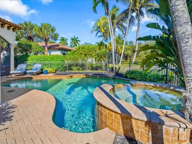 Combined pool / hot tub with a fenced backyard and a patio