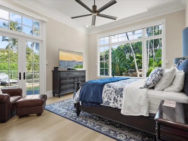 Primary bedroom suite with french doors to the pool and lovely views of the landscaping and waterfalls.