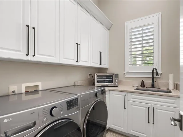 Laundry room with upper cabinets and standalone sink.