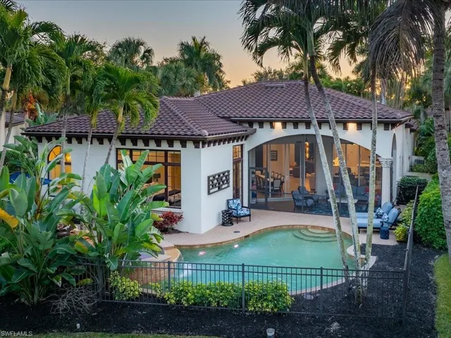 Rear view of house with a patio area, a tile roof, and stucco siding