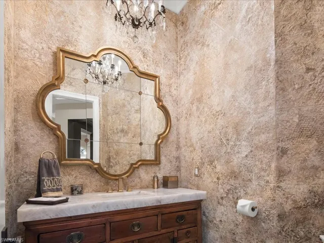Powder room with faux painting, dramatic mirror and lighting.