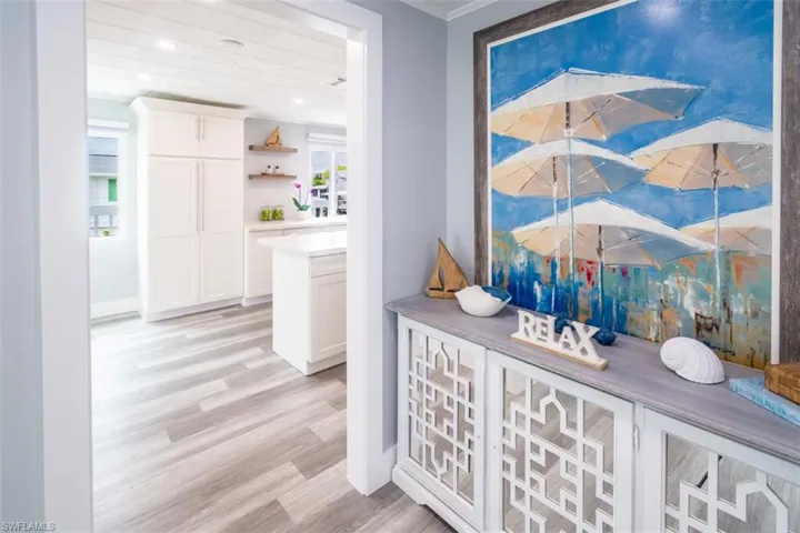 Hall featuring light wood-type flooring and crown molding