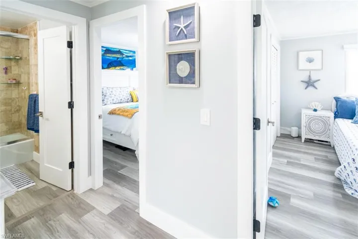 Hallway featuring light wood-type flooring and crown molding