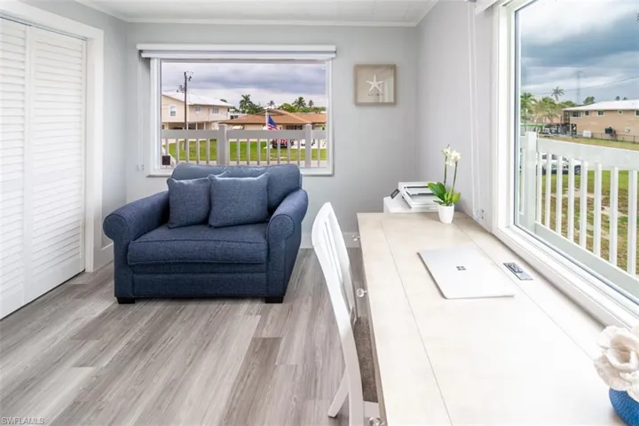Living room with light wood-style flooring and crown molding