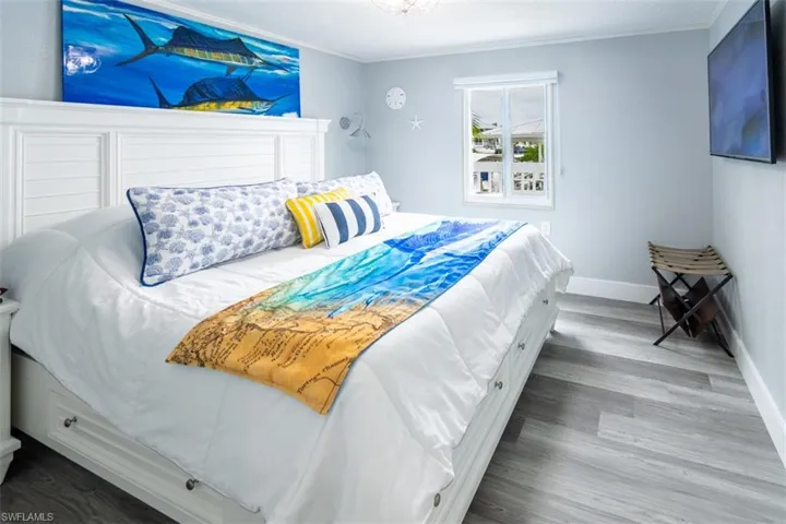 Bedroom with ornamental molding and light wood finished floors