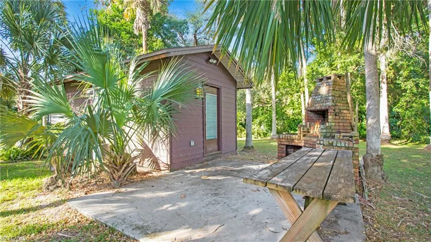 Additional enclosed workshop space with electric and two entrances (one side has a ramp) and amazing entertaining space with cookout and concrete, perfect for family nights.