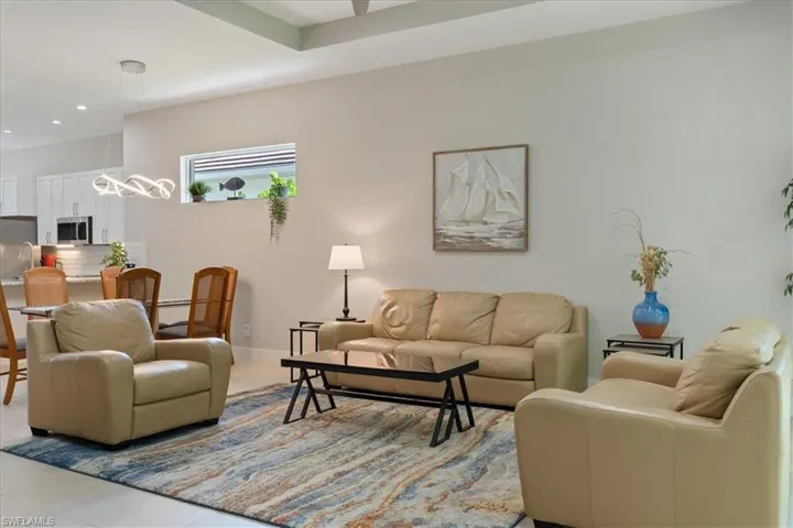 Living area with recessed lighting, light tile patterned flooring, and a chandelier