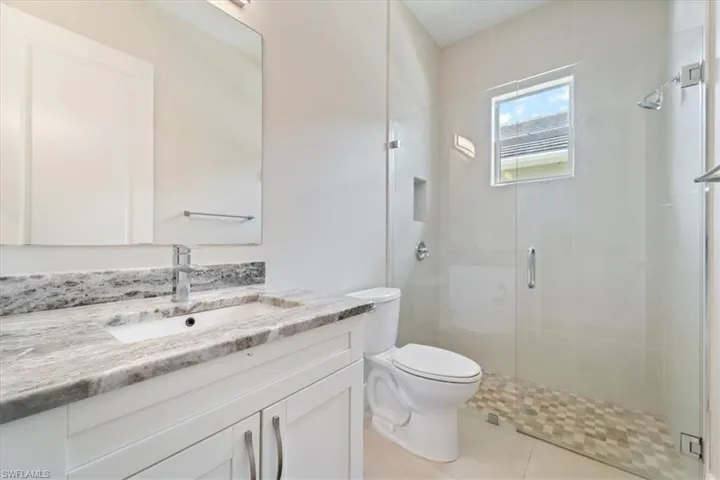 Bathroom with vanity, a stall shower, and tile patterned floors
