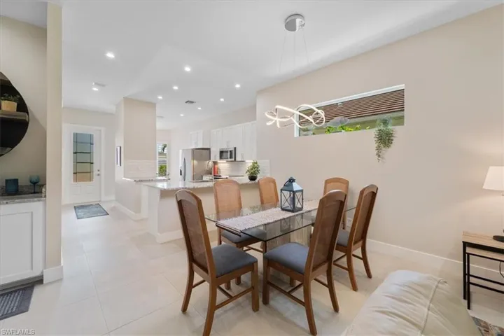 Dining area featuring recessed lighting, light tile patterned flooring, and a chandelier