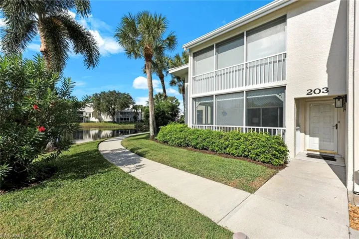 Surrounding community with a water view, a yard, and a sunroom