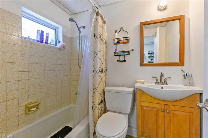 Bathroom with shower / bathtub combination with curtain and vanity