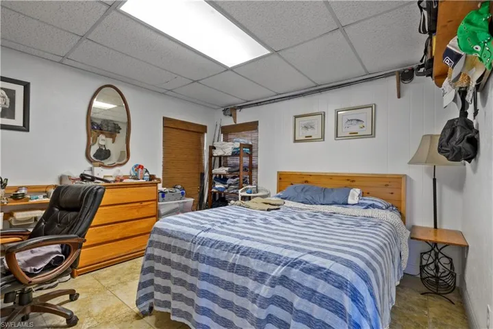 Bedroom with a paneled ceiling and an office area
