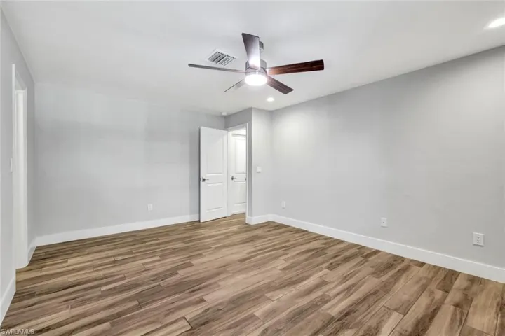 Unfurnished bedroom with wood finished floors, a ceiling fan, and recessed lighting