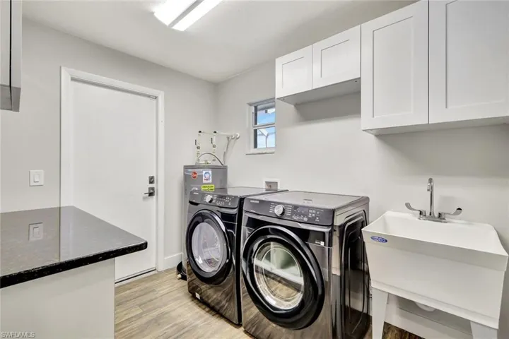 Washroom featuring cabinet space, light wood-style floors, and washing machine and dryer