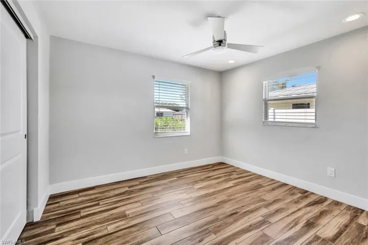 Unfurnished bedroom featuring a closet, wood finished floors, ceiling fan, and recessed lighting