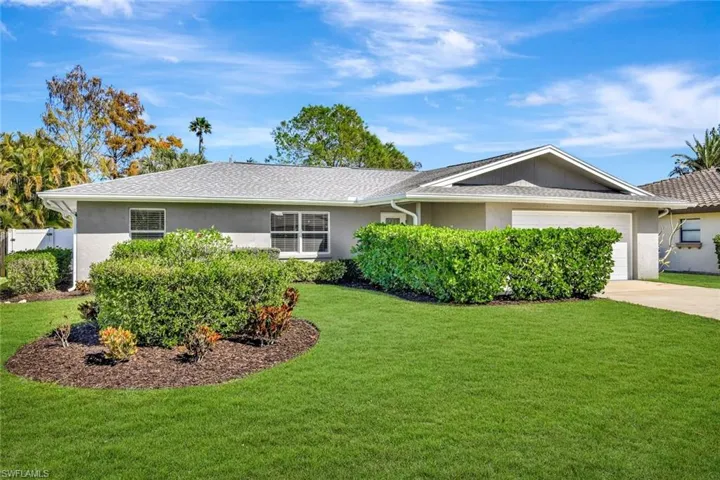 Ranch-style house featuring stucco siding, a front yard, concrete driveway, and a garage