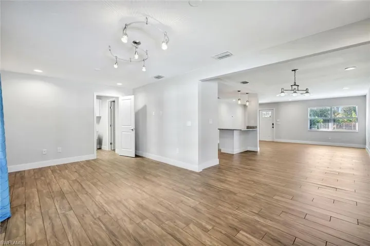Unfurnished living room with a chandelier, light wood-style flooring, and recessed lighting