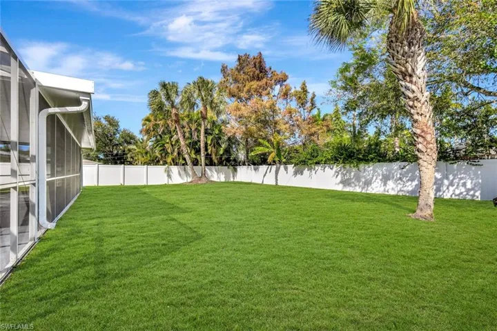 Fenced backyard with a sunroom