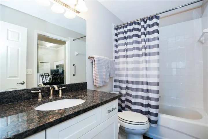 Full bathroom featuring toilet, shower / bath combo with shower curtain, and vanity