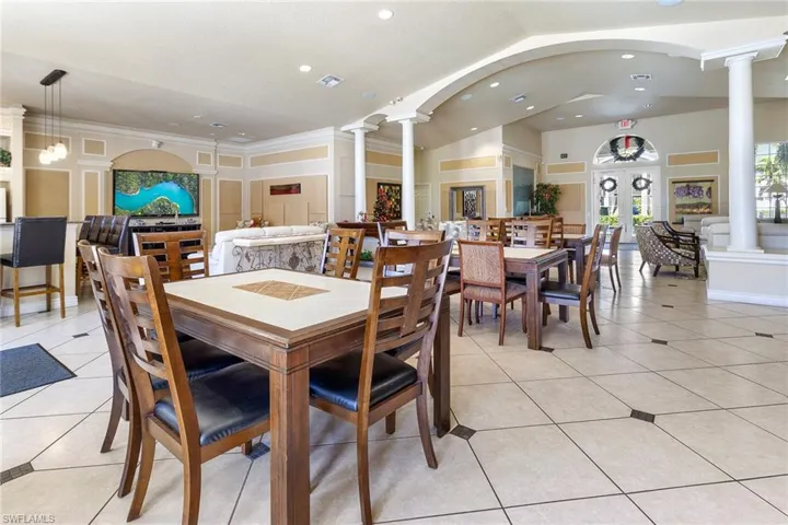 Dining space with lofted ceiling, light tile patterned floors, decorative columns, and recessed lighting