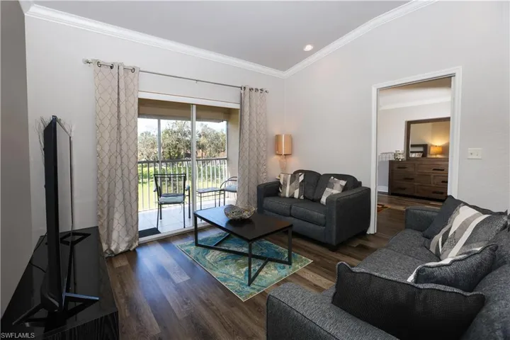 Living area with ornamental molding and wood finished floors