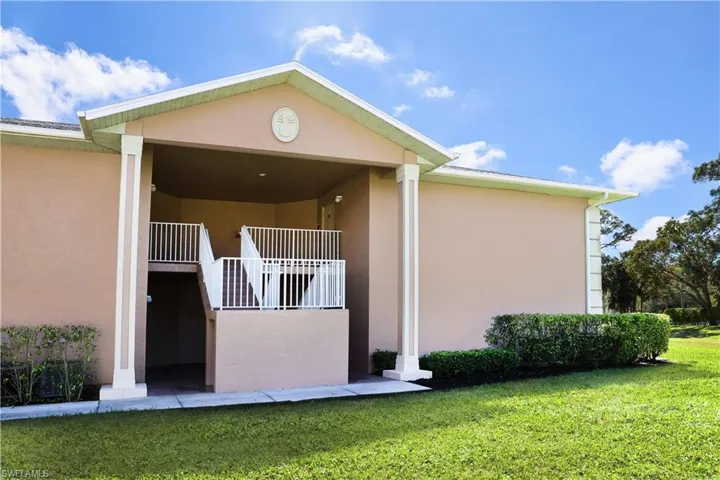 View of side of property featuring a yard and stucco siding