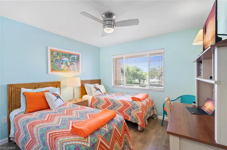 Guest Bedroom featuring ceiling fan, wood like floors and window.