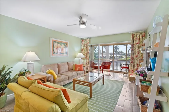 Living room featuring ceiling fan and a water view