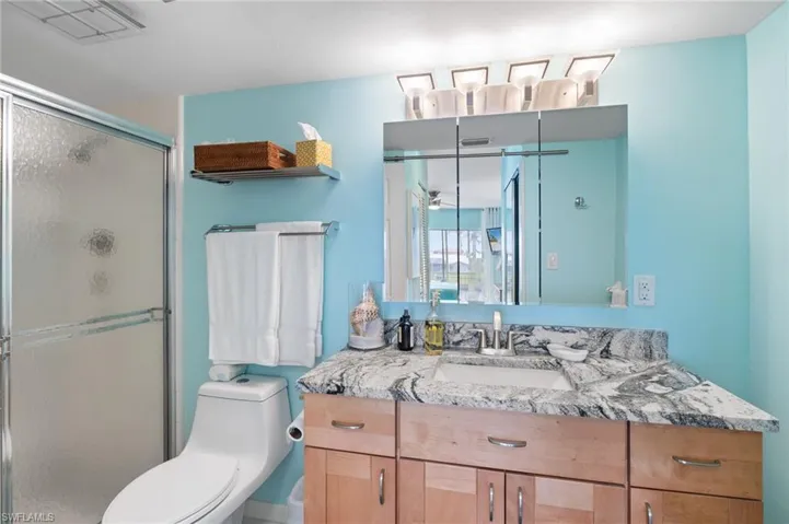 Beautiful Bathroom with a shower with glass door, toilet, and vanity