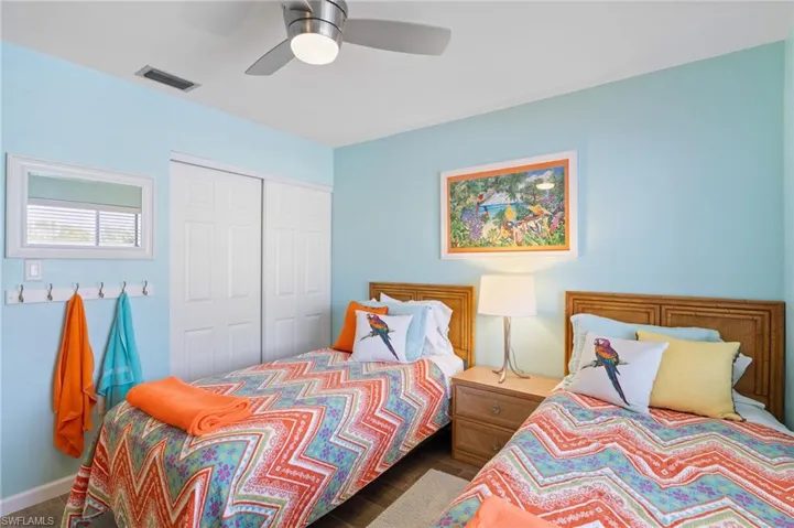 Guest Bedroom featuring ceiling fan, dark wood-type flooring, and a closet