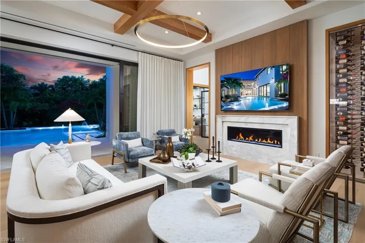 Living area with wood finished floors, a premium fireplace, recessed lighting, beamed ceiling, and coffered ceiling