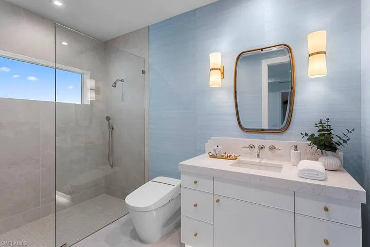 Bathroom with walk in shower, tile walls, toilet, and vanity
