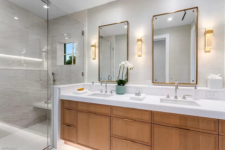 Full bath featuring double vanity and a stall shower
