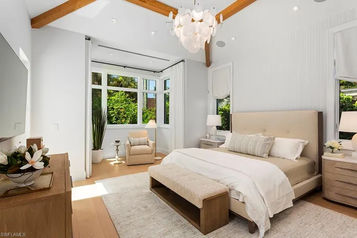 Bedroom featuring wood finished floors, a chandelier, and beam ceiling