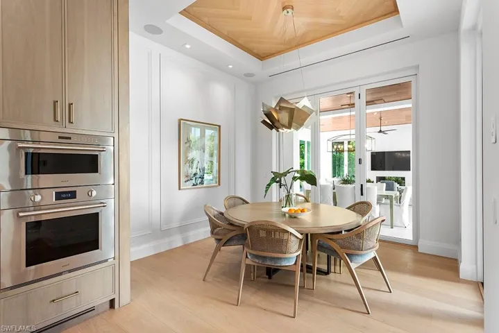 Dining area featuring a raised ceiling, light wood-type flooring, and baseboards