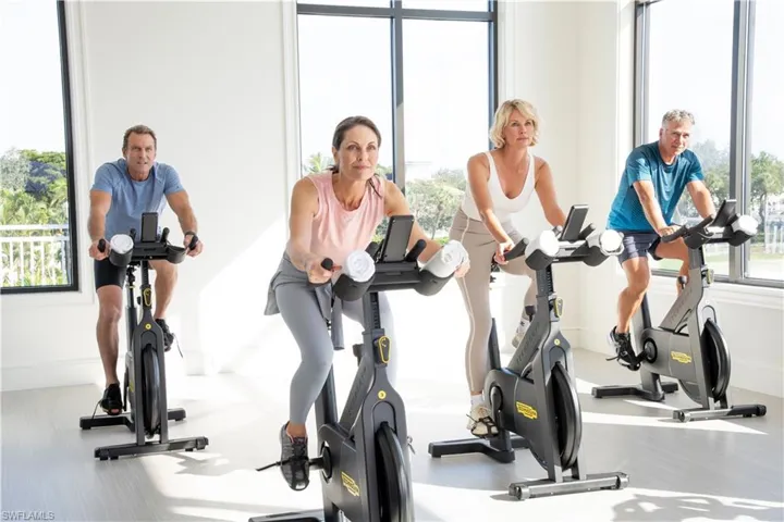 Fitness space featuring large windows and neutral flooring
