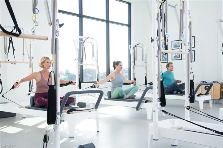 Multi-purpose fitness room featuring large-format windows with dark frames and light-toned flooring