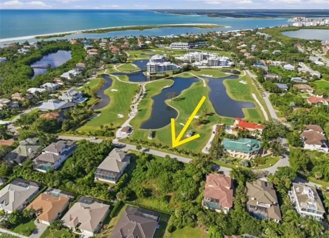 Aerial perspective of residential lot featuring direct proximity to a golf course, expansive greenery, and coastal surroundings