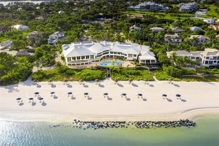 Direct beachfront estate featuring private sand access, an expansive outdoor swimming pool, multi-level terraces, and a sprawling architectural footprint
