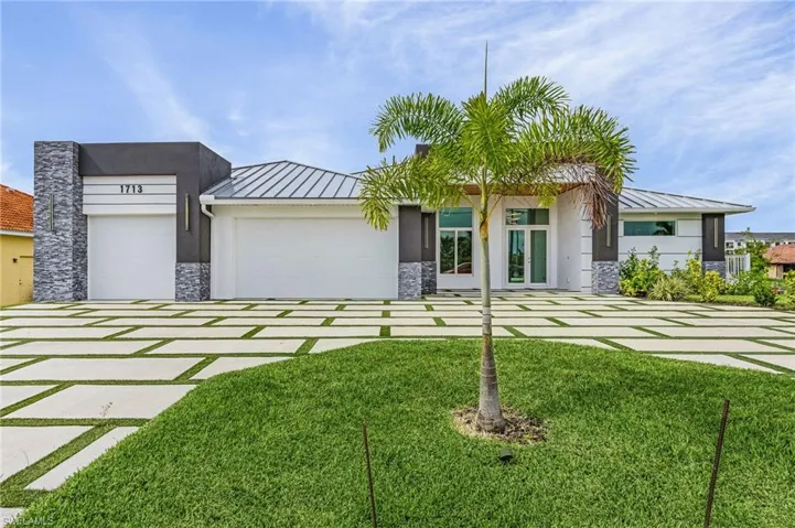 View of front facade with a front yard and the garage