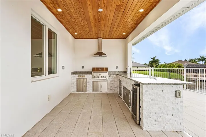 View of patio with wine cooler, area for grilling, an outdoor wet bar, and a grill