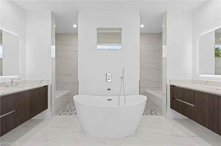 Master Bathroom with two showers, separate bathtub, vanity
