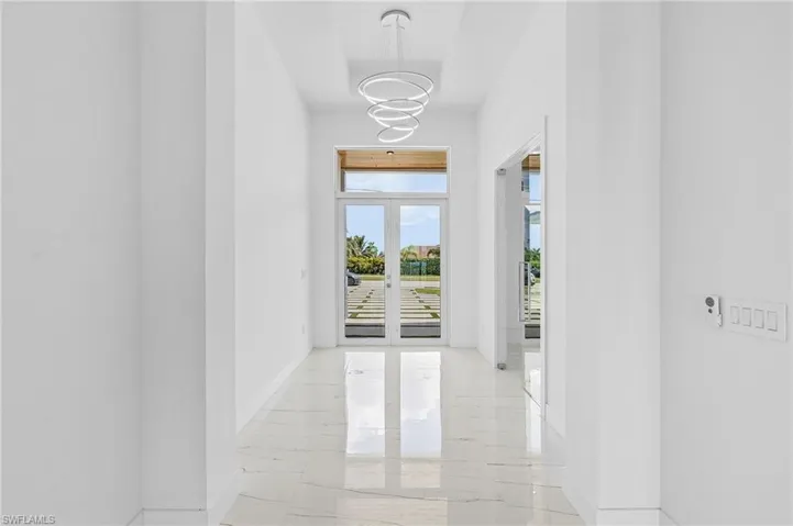 Hallway featuring a chandelier and french doors