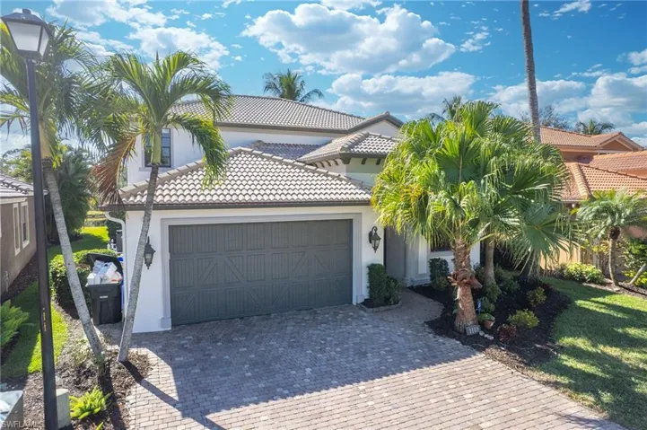 Mediterranean / spanish-style house with a tiled roof, stucco siding, decorative driveway, and a garage