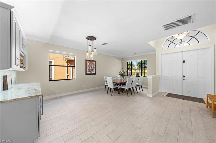 Entrance foyer featuring a chandelier, ornamental molding, and wood finish floors