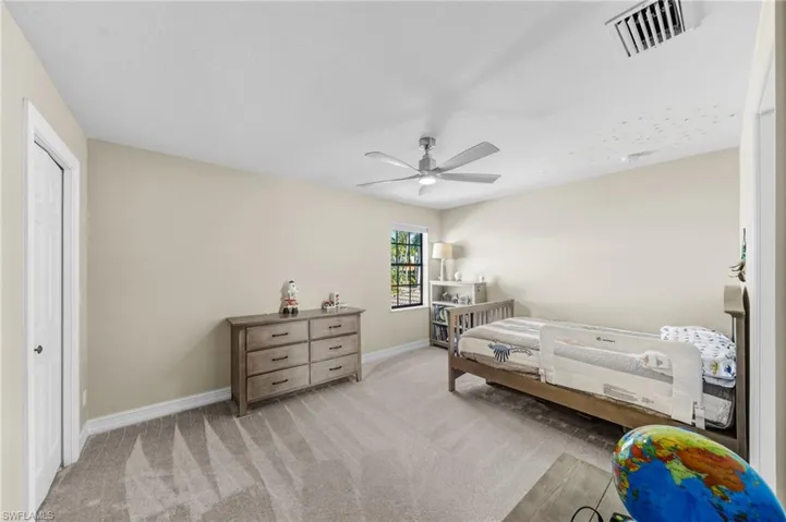 Bedroom featuring light colored carpet and ceiling fan