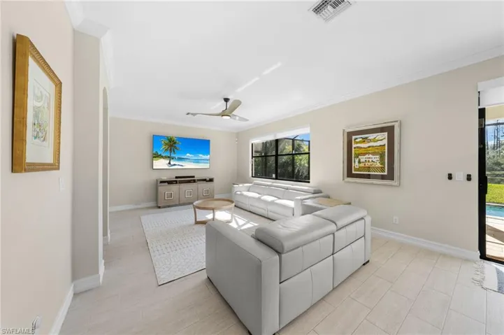 Living room featuring a ceiling fan and crown molding