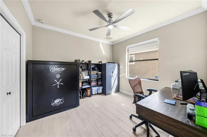 Office space with ornamental molding, wood finish floors, and ceiling fan