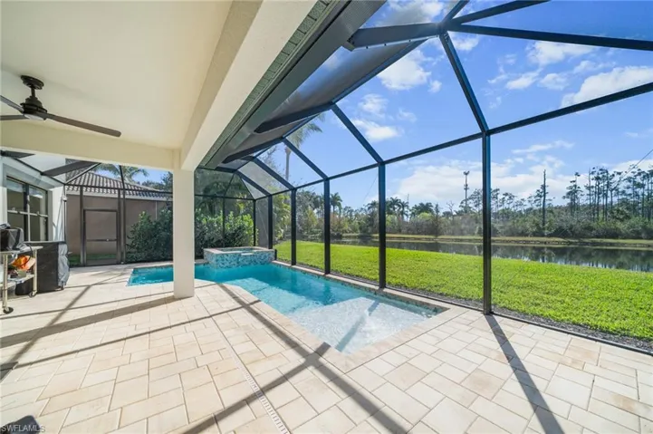 View of swimming pool featuring a sunroom, a lanai, a patio, and a yard