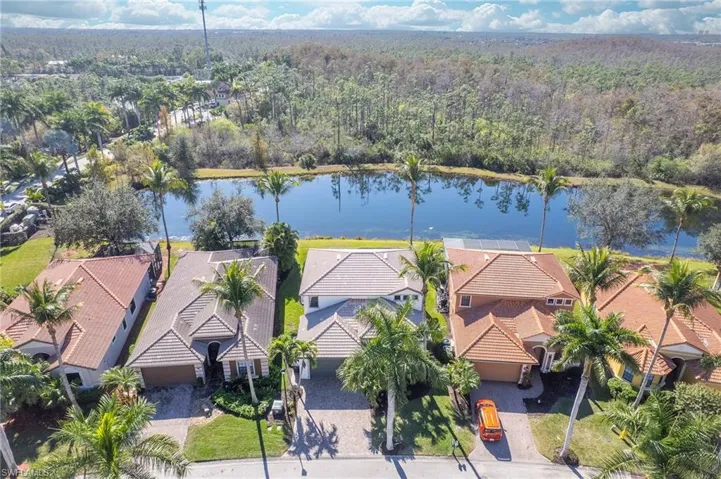 Aerial perspective of suburban area with a large body of water and a heavily wooded area